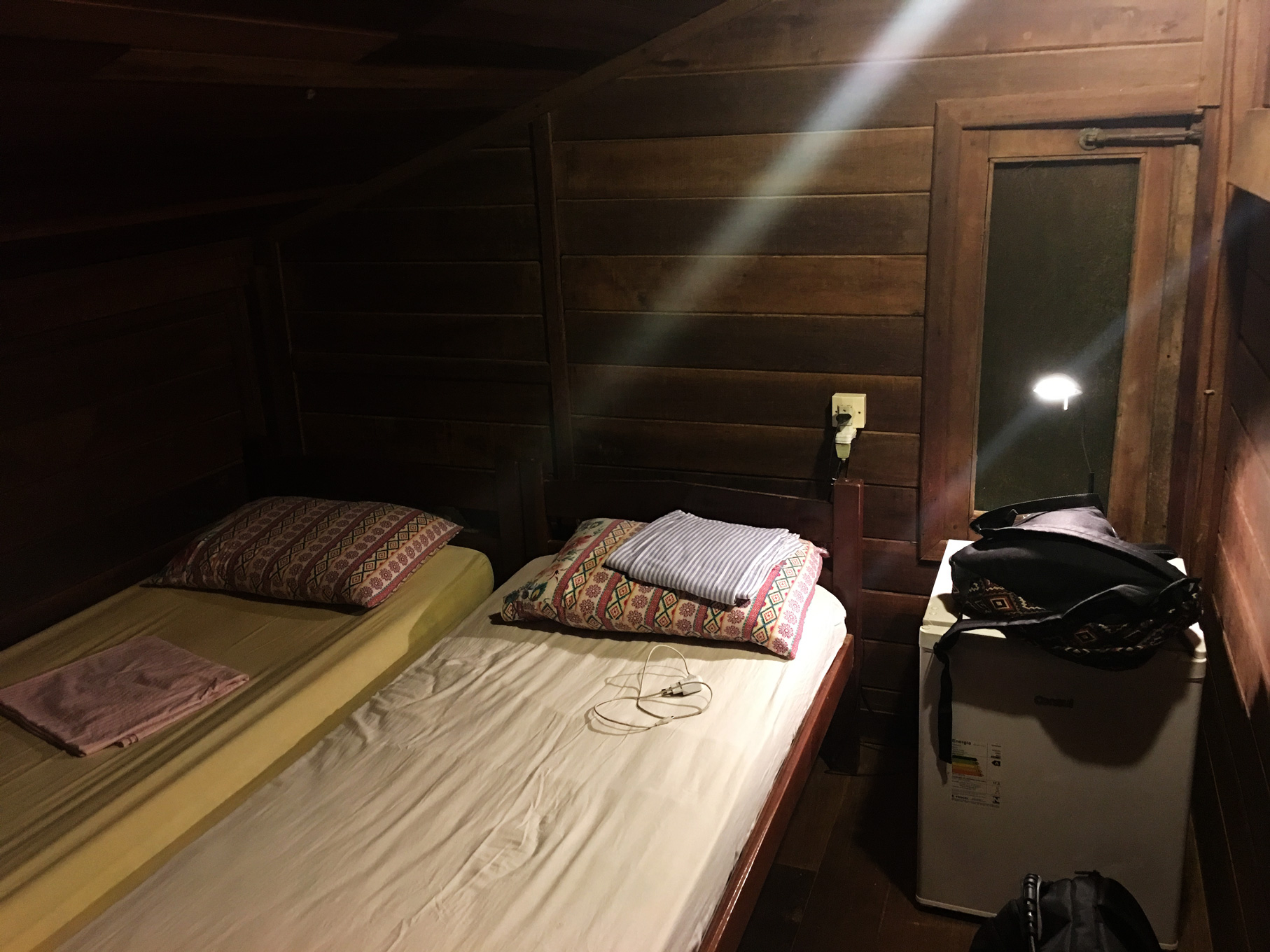 Quarto no sótão com duas camas de solteiro e um frigobar na casa do George Gringo em Fernando de Noronha.