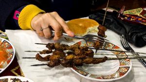 Amanda comendo kebabs na praça Jeema el Fna em Marrakech, Marrocos.